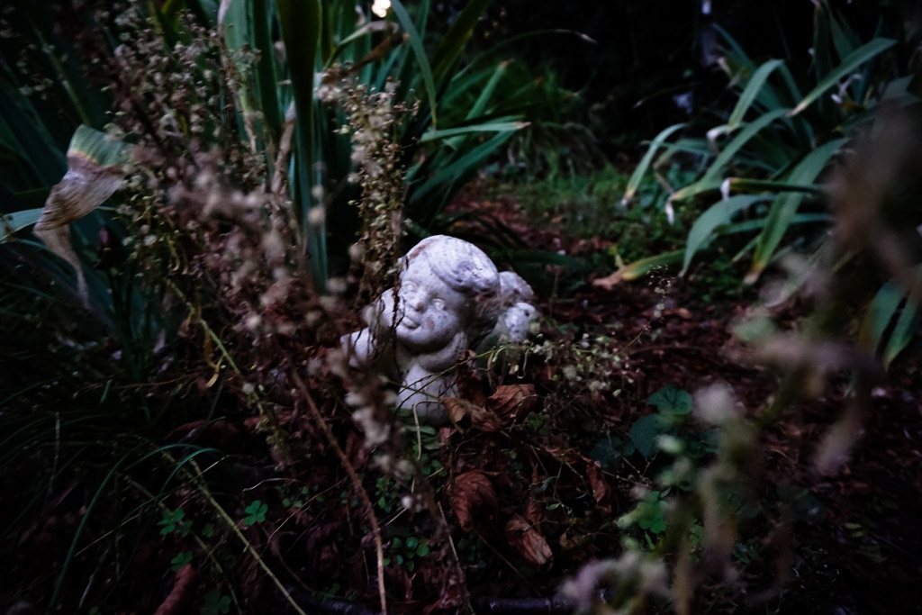 Overgrown figure in cemetery. 