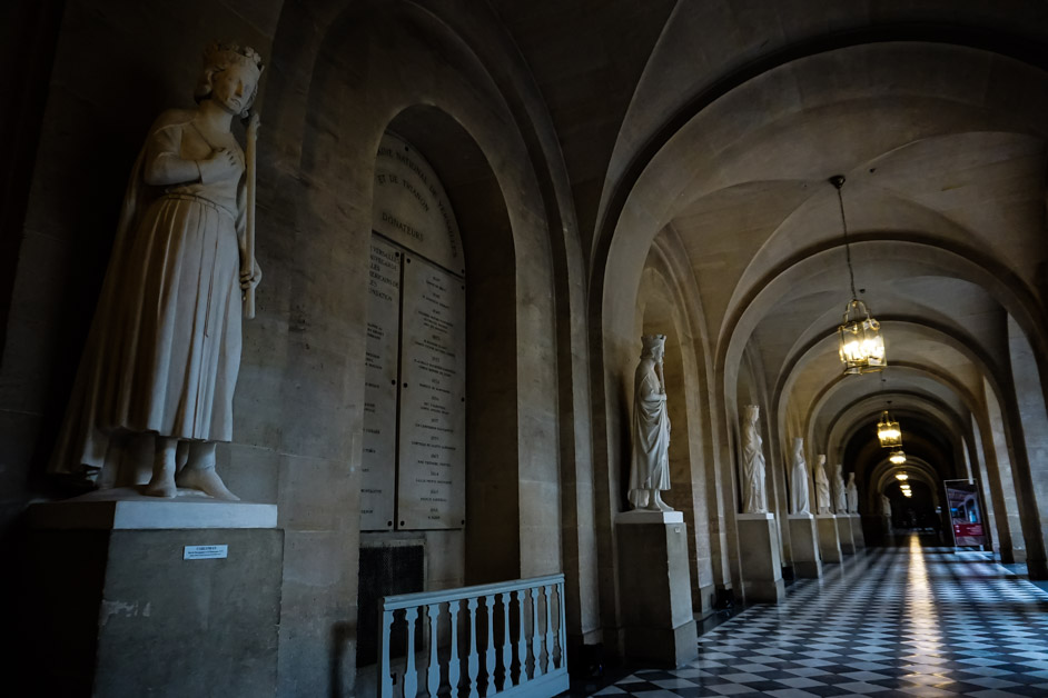 Dimly lit Palace of Versailles hallways. 